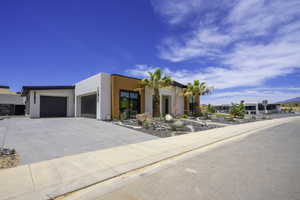 Modern home featuring an attached garage, stucco siding, and driveway