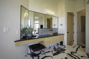 Bathroom with vanity and decorative backsplash