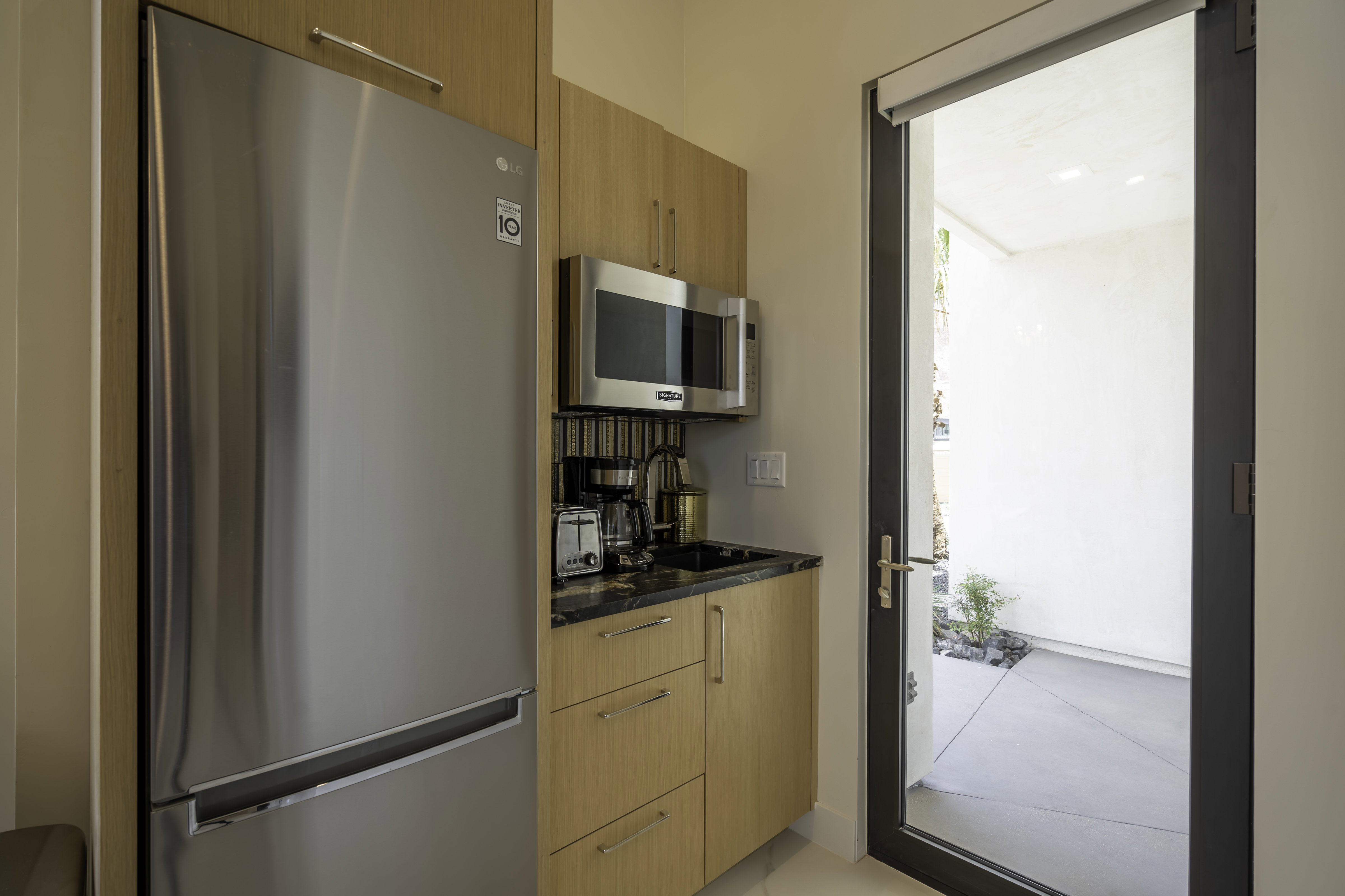 Kitchen with stainless steel appliances, modern cabinets, and light wood finish cabinets