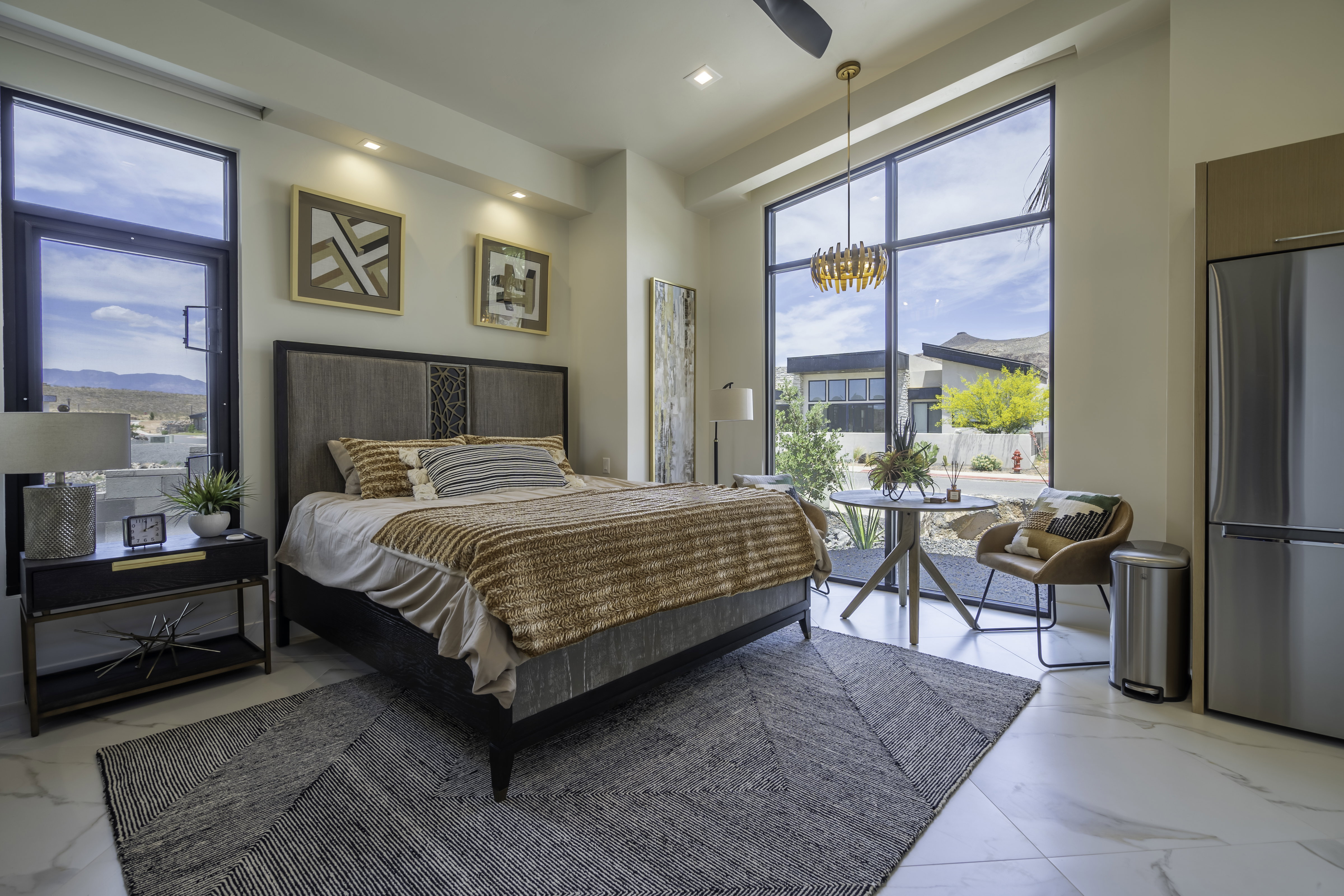 Bedroom with freestanding refrigerator, light marble finish floors, access to exterior, and ceiling fan