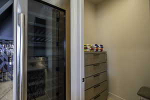 Bathroom with a shower stall, wine cooler, and vanity