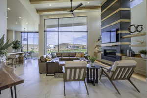 Living area featuring a tiled fireplace, ceiling fan, and recessed lighting