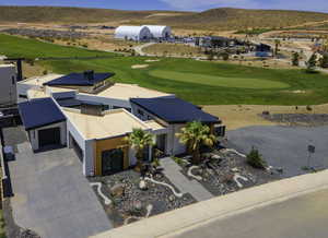 Aerial view of property and surrounding area with a local golf course and a mountain backdrop