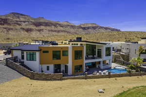 Back of house with a patio area, stucco siding, a fenced backyard, a mountain view, and a standing seam roof