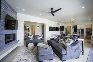 Living area with a ceiling fan, a high end fireplace, recessed lighting, and built in shelves