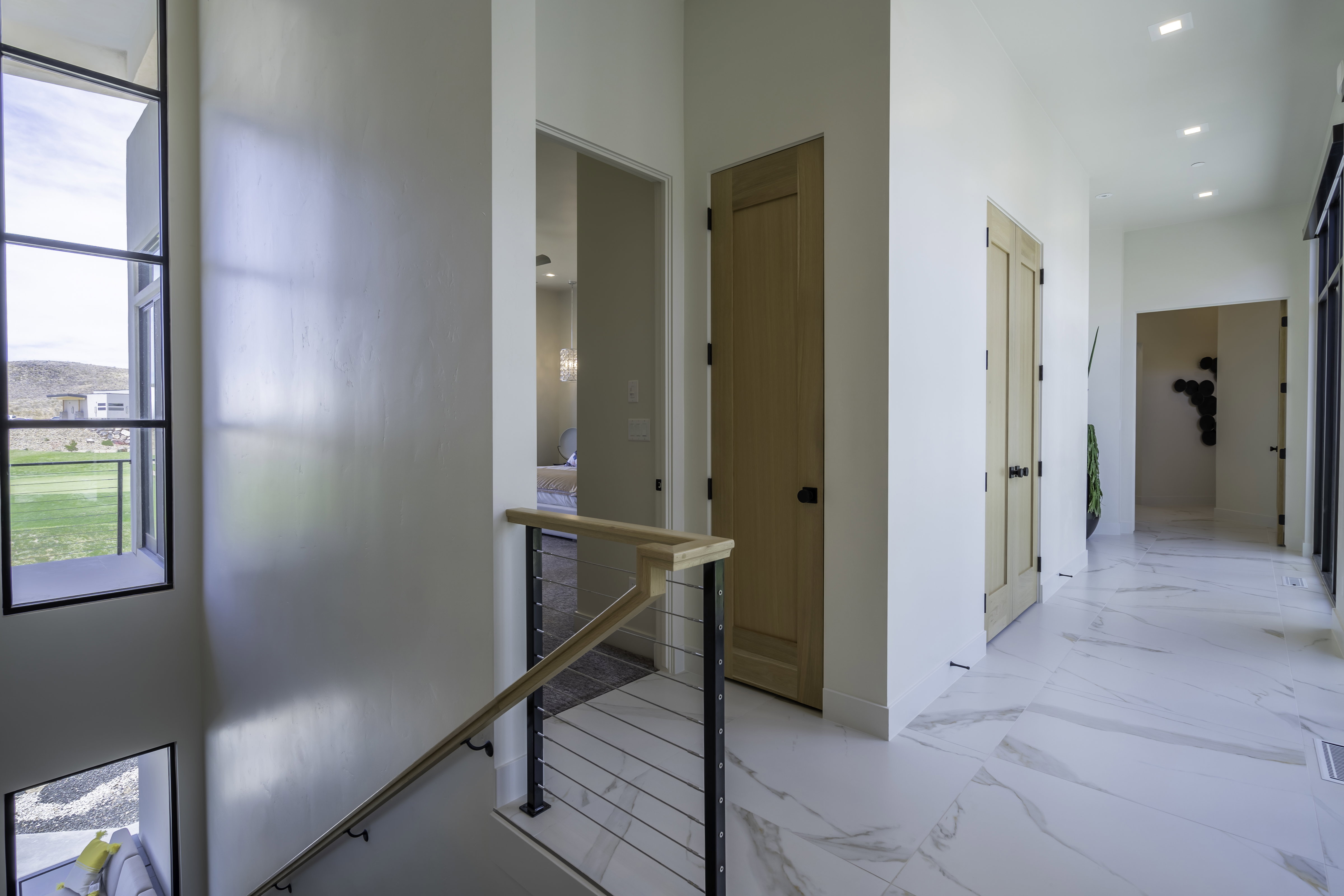 Hallway featuring an upstairs landing, recessed lighting, and light marble finish flooring