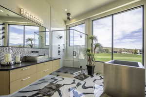 Full bath with a stall shower, vanity, healthy amount of natural light, tasteful backsplash, and recessed lighting