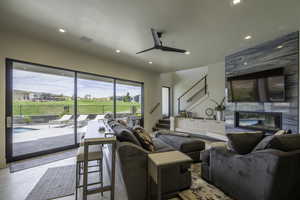 Living room featuring ceiling fan, recessed lighting, and a premium fireplace