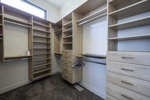 Walk in closet featuring dark carpet
