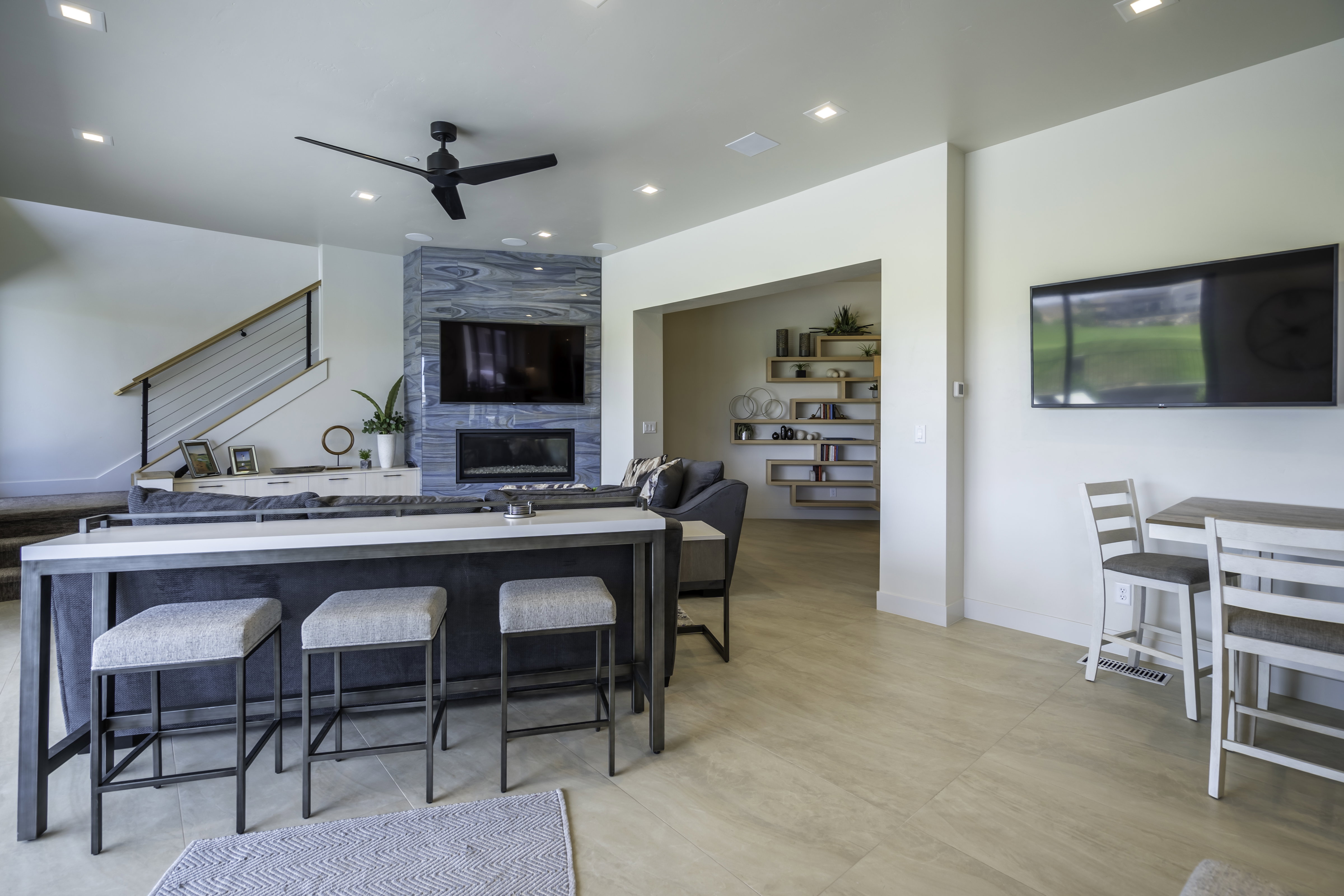 Kitchen featuring a tile fireplace, a ceiling fan, open floor plan, recessed lighting, and a breakfast bar