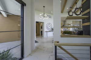 Hall with a chandelier and baseboards