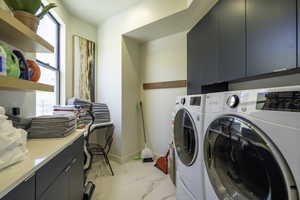 Laundry room featuring cabinet space and separate washer and dryer