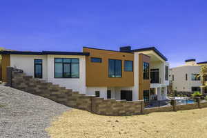 Back of house featuring stucco siding, an outdoor pool, and a patio area