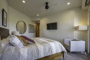 Carpeted bedroom featuring a ceiling fan and recessed lighting