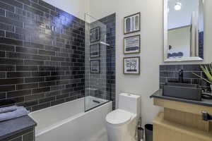 Bathroom featuring vanity, tasteful backsplash, and shower / tub combination