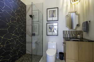 Full bathroom featuring a marble finish shower and vanity