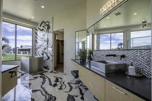 Full bath featuring a walk in closet, vanity, recessed lighting, and tasteful backsplash