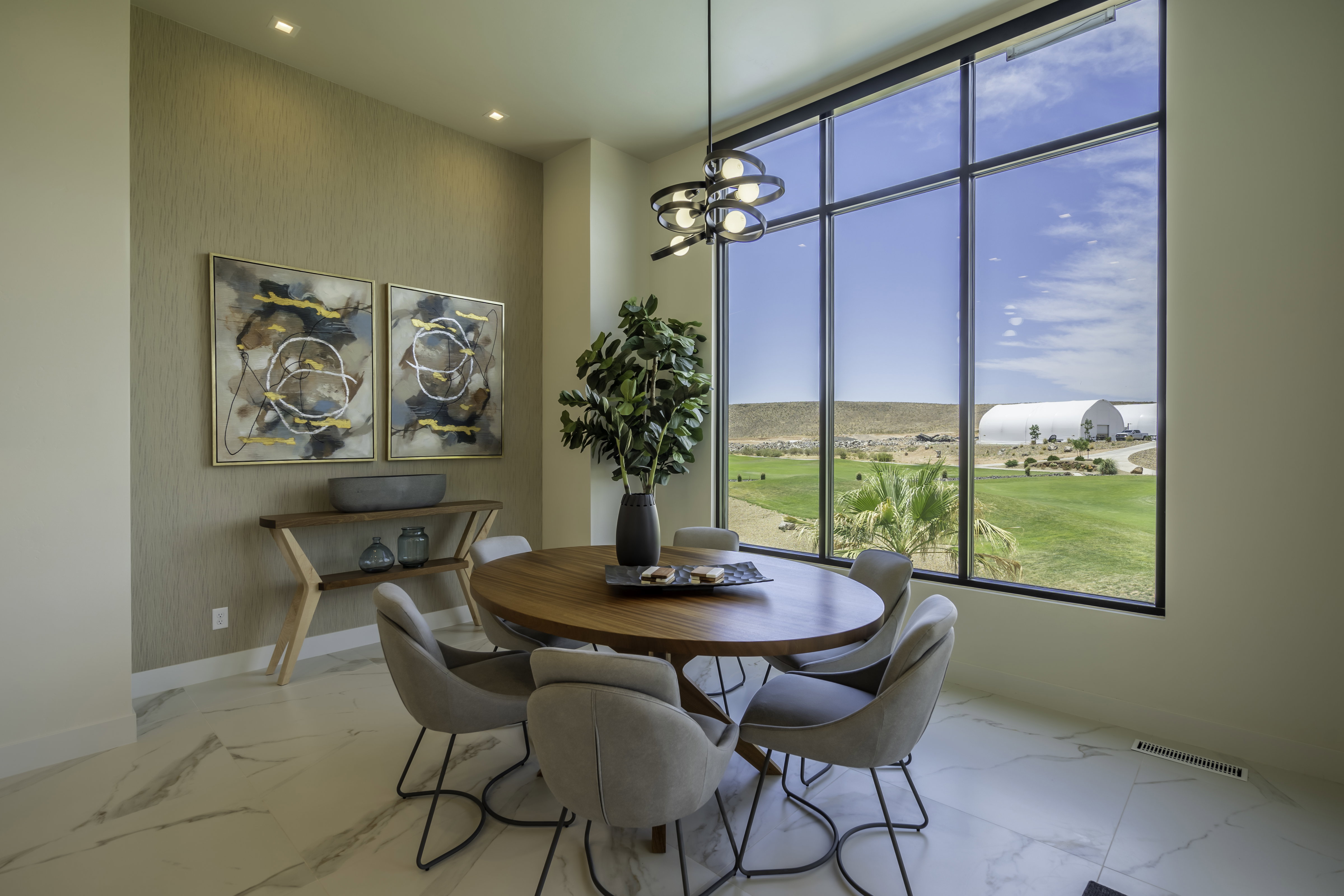 Dining space with suspended lighting and light marble finish floors