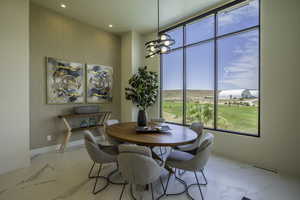 Dining space with suspended lighting and light marble finish floors