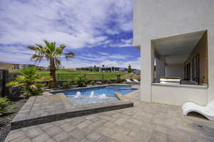 Combined pool / hot tub with a patio, area for grilling, a fenced backyard, and a residential view