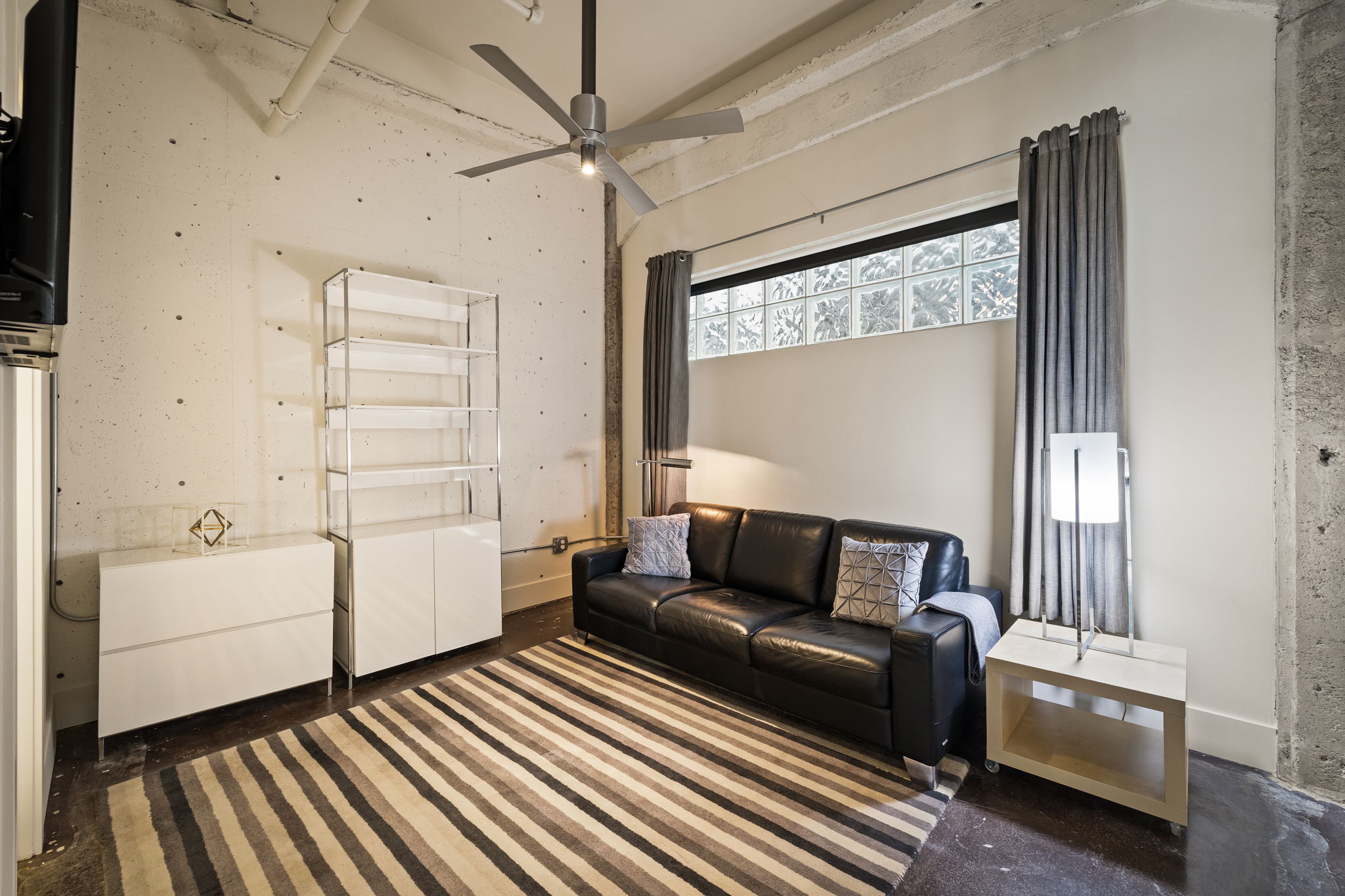 Living area with ceiling fan and a high ceiling