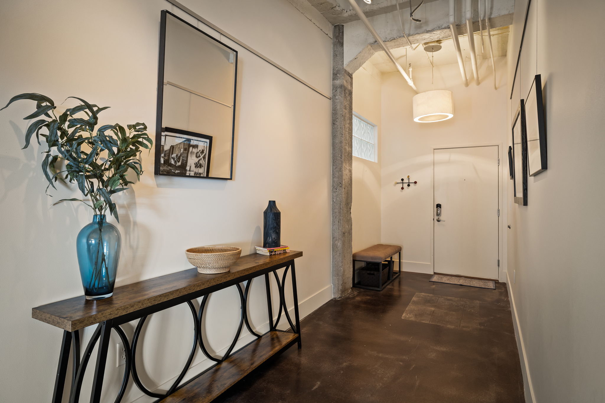 Hallway featuring concrete flooring and a high concrete ceiling