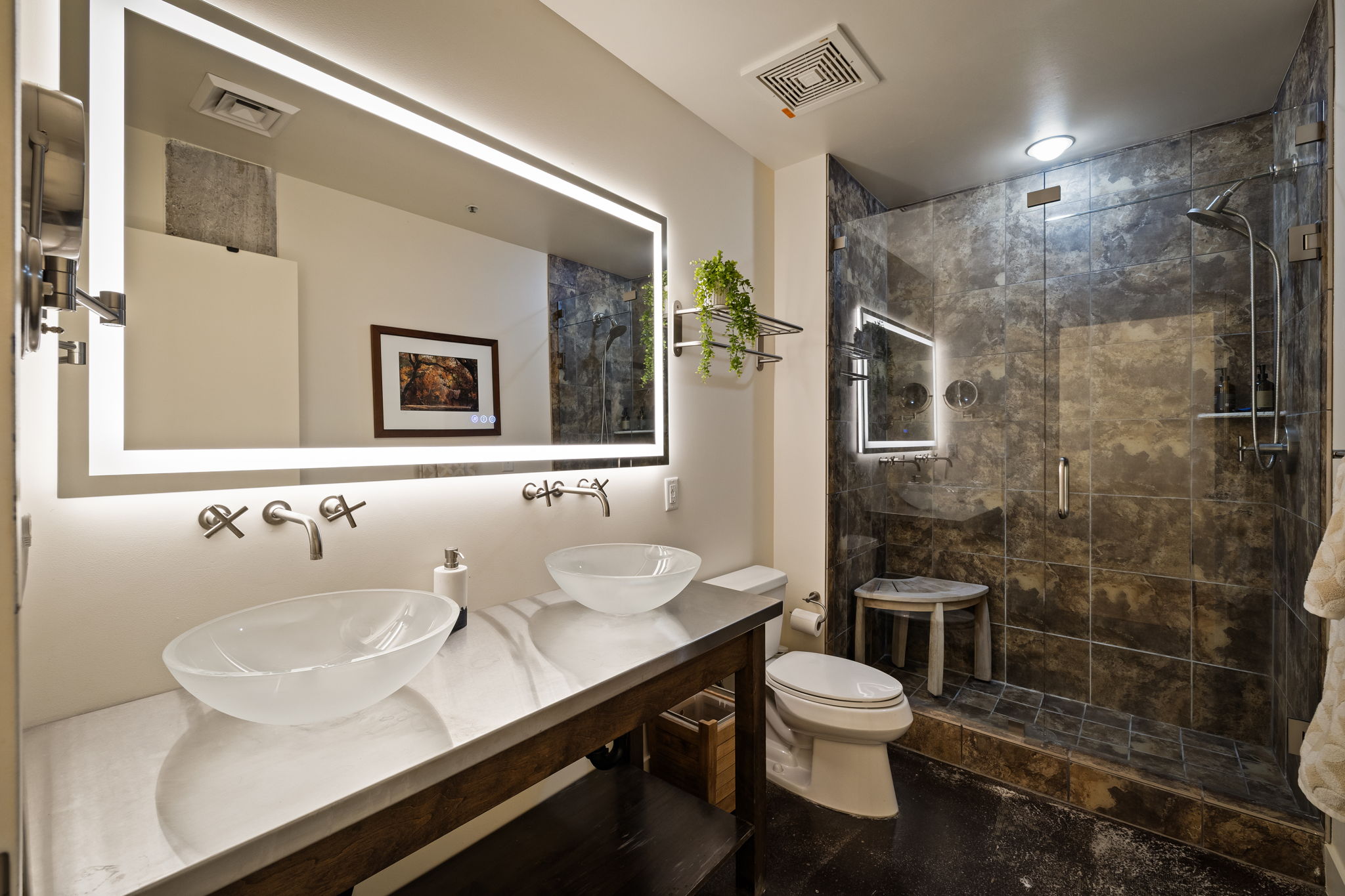 Full bath with double vanity and a stall shower