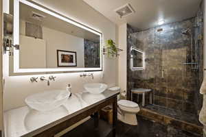 Full bath with double vanity and a stall shower