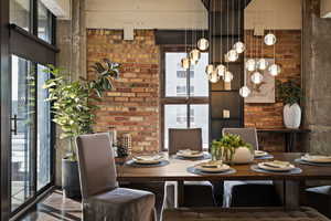 Dining room featuring healthy amount of natural light and brick wall
