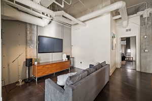Living area featuring a high ceiling and concrete flooring
