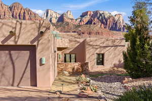 View of home's exterior with an attached garage, a patio area, a mountain view, stucco siding, and concrete driveway