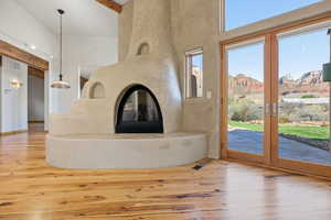 Unfurnished living room featuring light wood-style flooring, french doors, a high ceiling, a premium fireplace, and a mountain view
