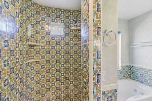 Full bath with tiled shower and a whirlpool tub