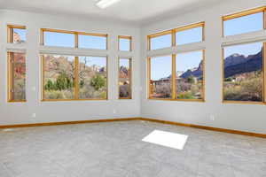 Unfurnished room with baseboards and a mountain view