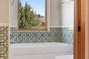 Bathroom with a bath and tile walls