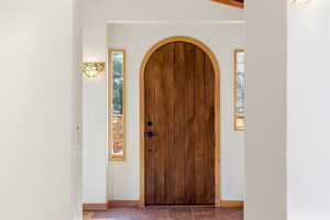 Foyer with arched walkways and baseboards