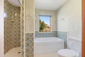 Full bath with a garden tub, a stall shower, tile walls, and light tile patterned floors