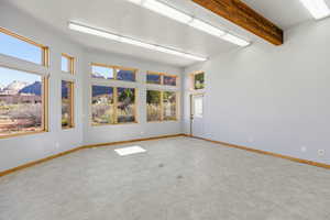 Empty room featuring beam ceiling and a mountain view