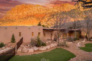 Back of property at dusk featuring stucco siding and a patio