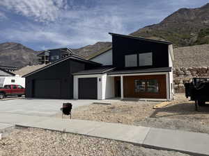 Modern home with a mountain view, a garage, and concrete driveway