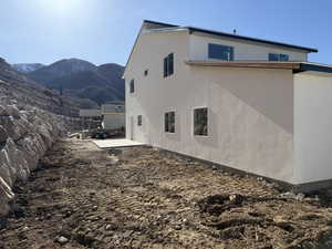 View of property exterior with stucco siding and a mountain view