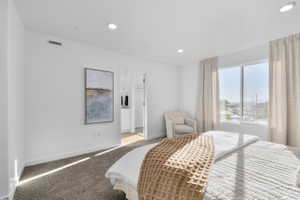 Carpeted bedroom featuring ensuite bath and recessed lighting