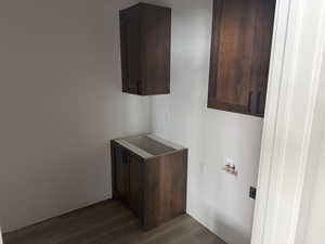 Laundry area with cabinet space, dark wood finished floors, and hookup for a washing machine