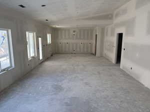 Unfurnished living room featuring lofted ceiling