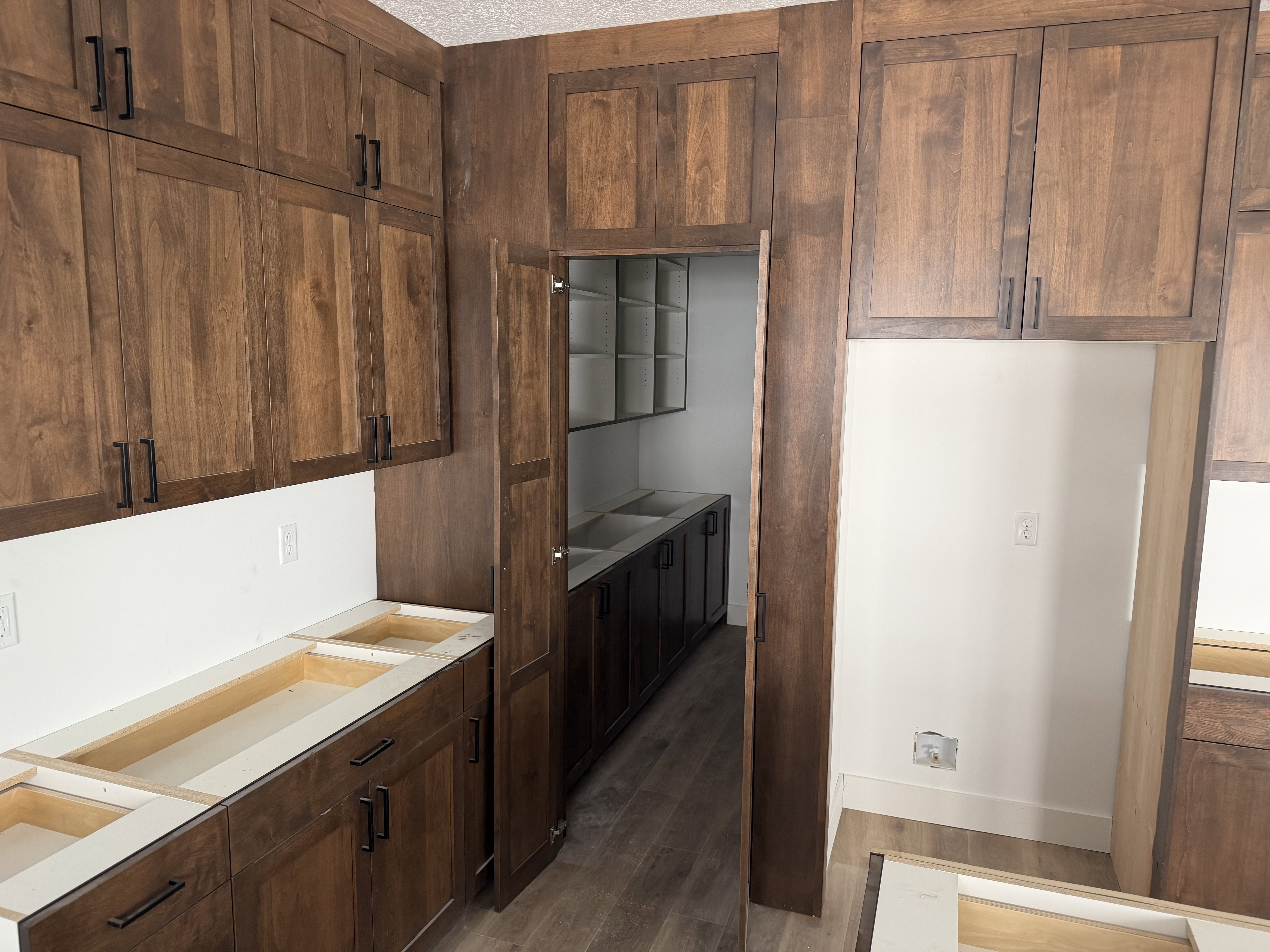 Kitchen featuring dark wood-style floors, dark wood finish cabinetry, and light countertops