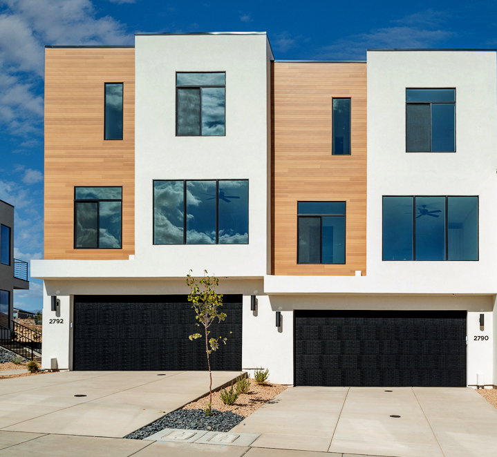 Contemporary home featuring stucco siding, a garage, and driveway