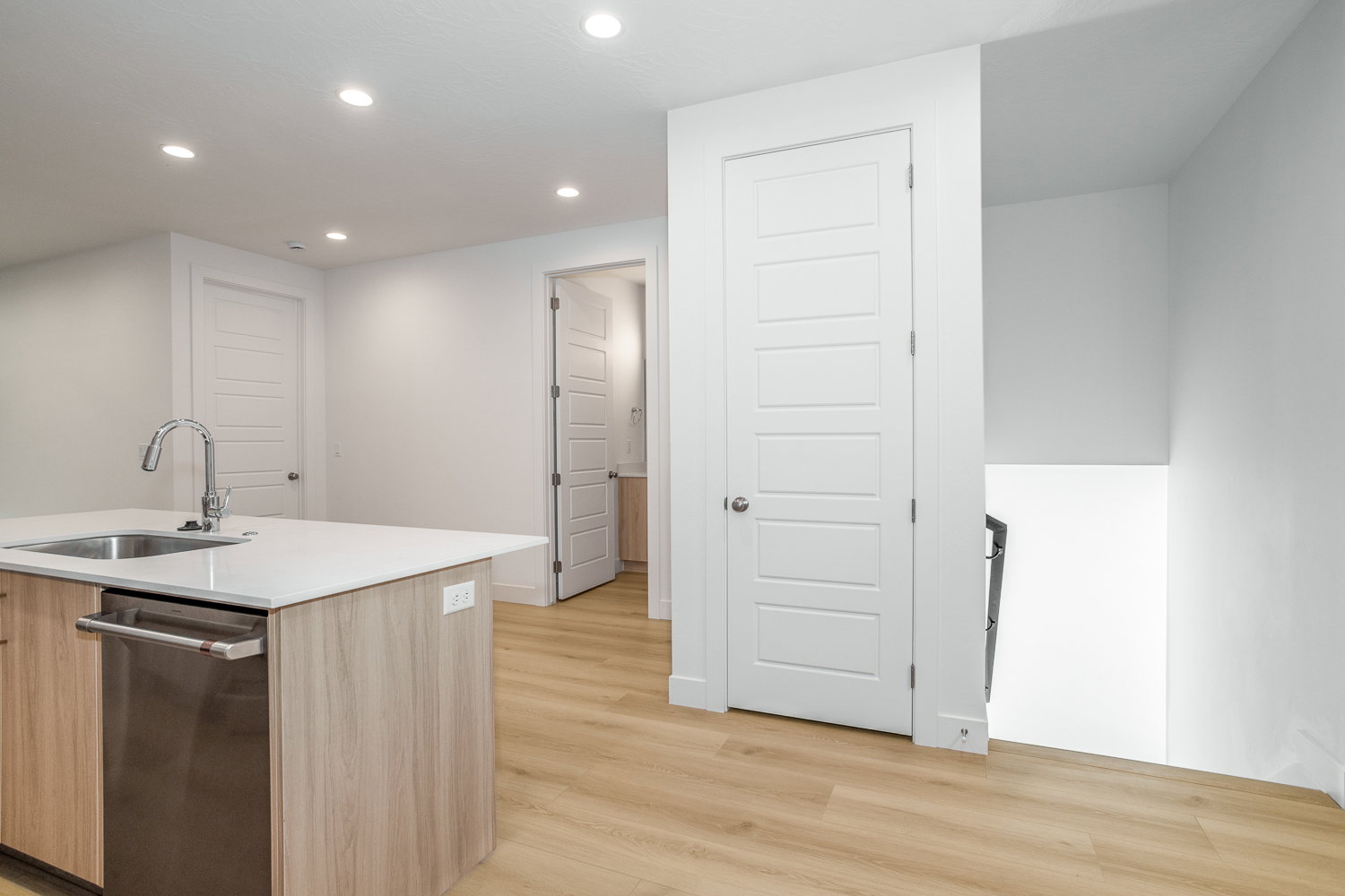 Kitchen with dishwasher, recessed lighting, light wood-style floors, modern cabinets, and a center island with sink