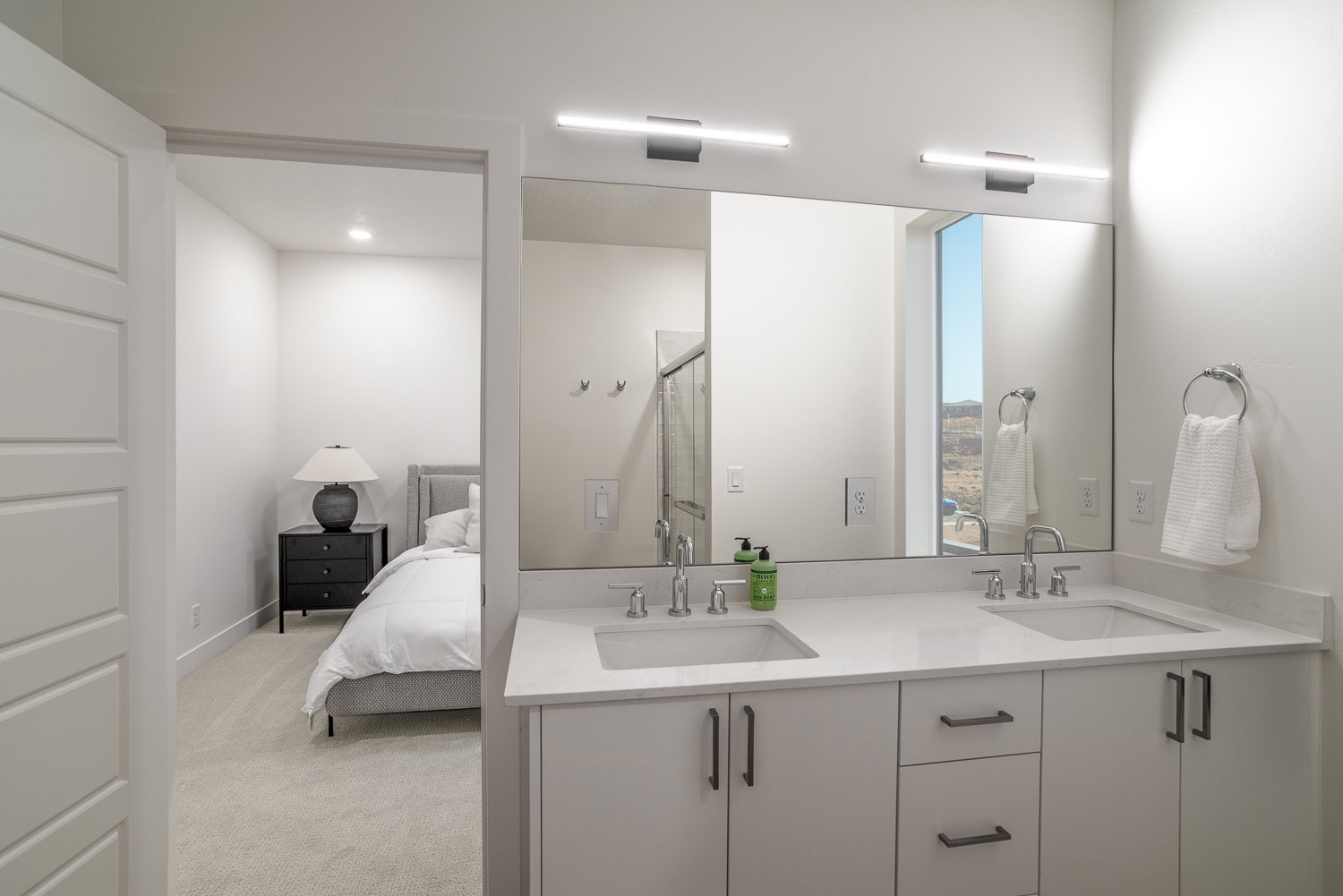 Ensuite bathroom with double vanity, light carpet, a stall shower, and recessed lighting