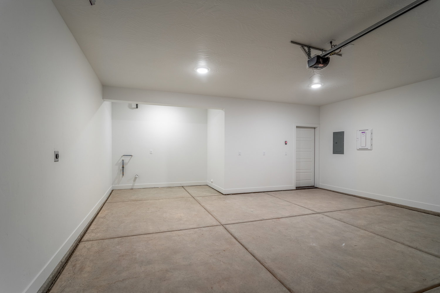 Garage featuring baseboards and electric panel