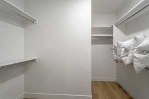 Walk in closet with light wood-style floors